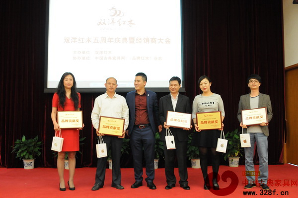 双洋红木五周年庆典上，河北唐山专卖店老板赵女士（图右二）领取“品牌贡献奖” 