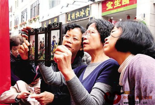 市民在观赏红木宫灯的精美做工 市民在观赏红木宫灯的精美做工