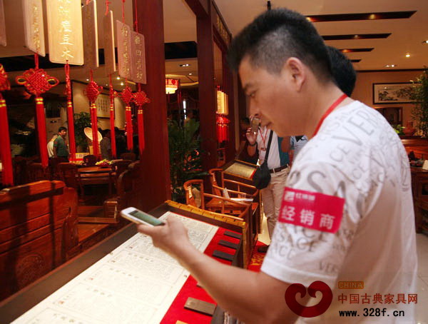 一名经销商正在用相机拍摄某品牌红木家具详细介绍 一名经销商正在用相机拍摄某品牌红木家具详细介绍