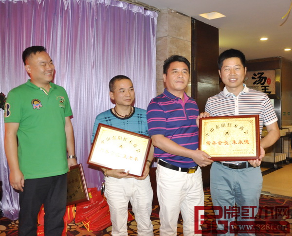 中山东阳红木商会会长、长丰红木董事长陈新丰(右二)为朱永德(右一)颁发奖牌 中山东阳红木商会会长、长丰红木董事长陈新丰(右二)为朱永德(右一)颁发奖牌