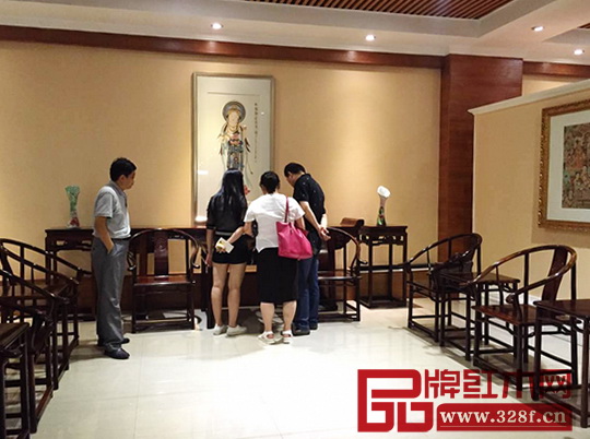 南枝红红木西安店内客户正在品味红木家具