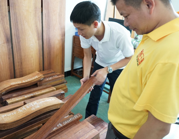 区氏臻品总经理区锦泽(左)与工匠一同严把黄花梨选料 区氏臻品总经理区锦泽(左)与工匠一同严把黄花梨选料