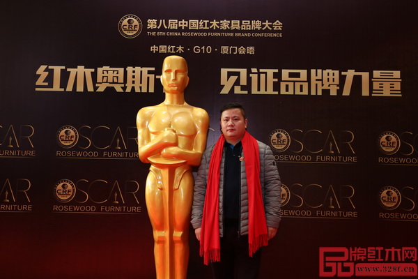 木缘红木董事长汪辉受邀出席第八届中国红木家具品牌大会并在活动主题背景板前留影 木缘红木董事长汪辉受邀出席第八届中国红木家具品牌大会并在活动主题背景板前留影