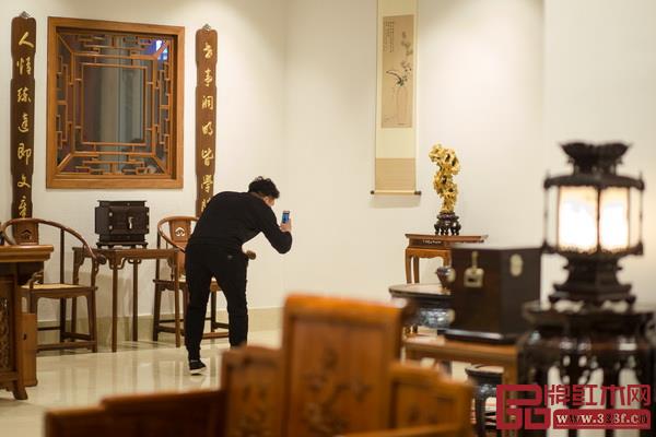 区氏臻品展厅内,家具爱好者正用手机拍照 区氏臻品展厅内,家具爱好者正用手机拍照
