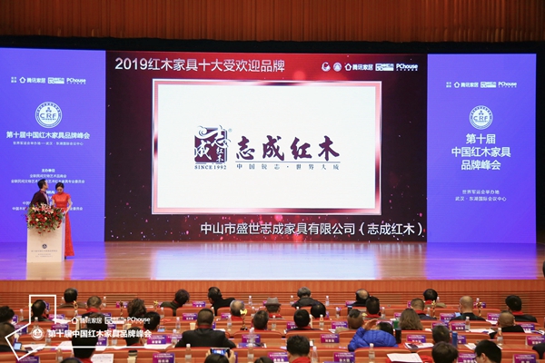 红木品牌峰会上,正播放志成红木荣获“2019红木家具十大受欢迎品牌”的颁奖视频 红木品牌峰会上,正播放志成红木荣获“2019红木家具十大受欢迎品牌”的颁奖视频